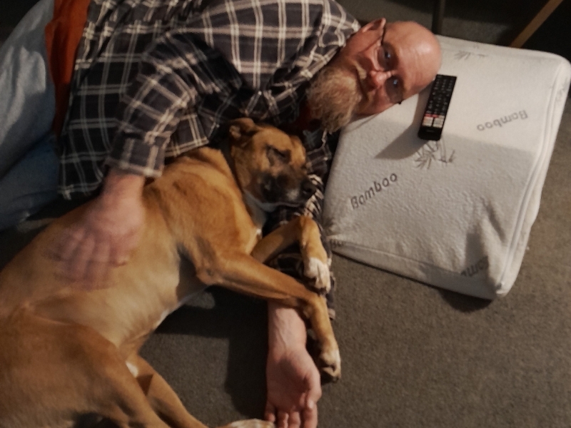 dog and man on ground having a cuddle